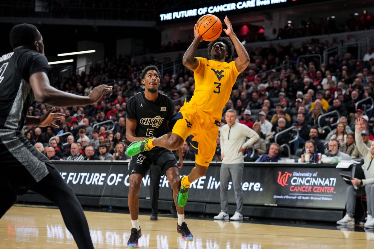 Feb 5, 2026; Cincinnati, Ohio, USA; West Virginia Mountaineers guard Honor Huff (3) drives to the basket against Cincinnati Bearcats guard Sencire Harris (5) in the second half at Fifth Third Arena. Mandatory Credit: Aaron Doster-Imagn Images