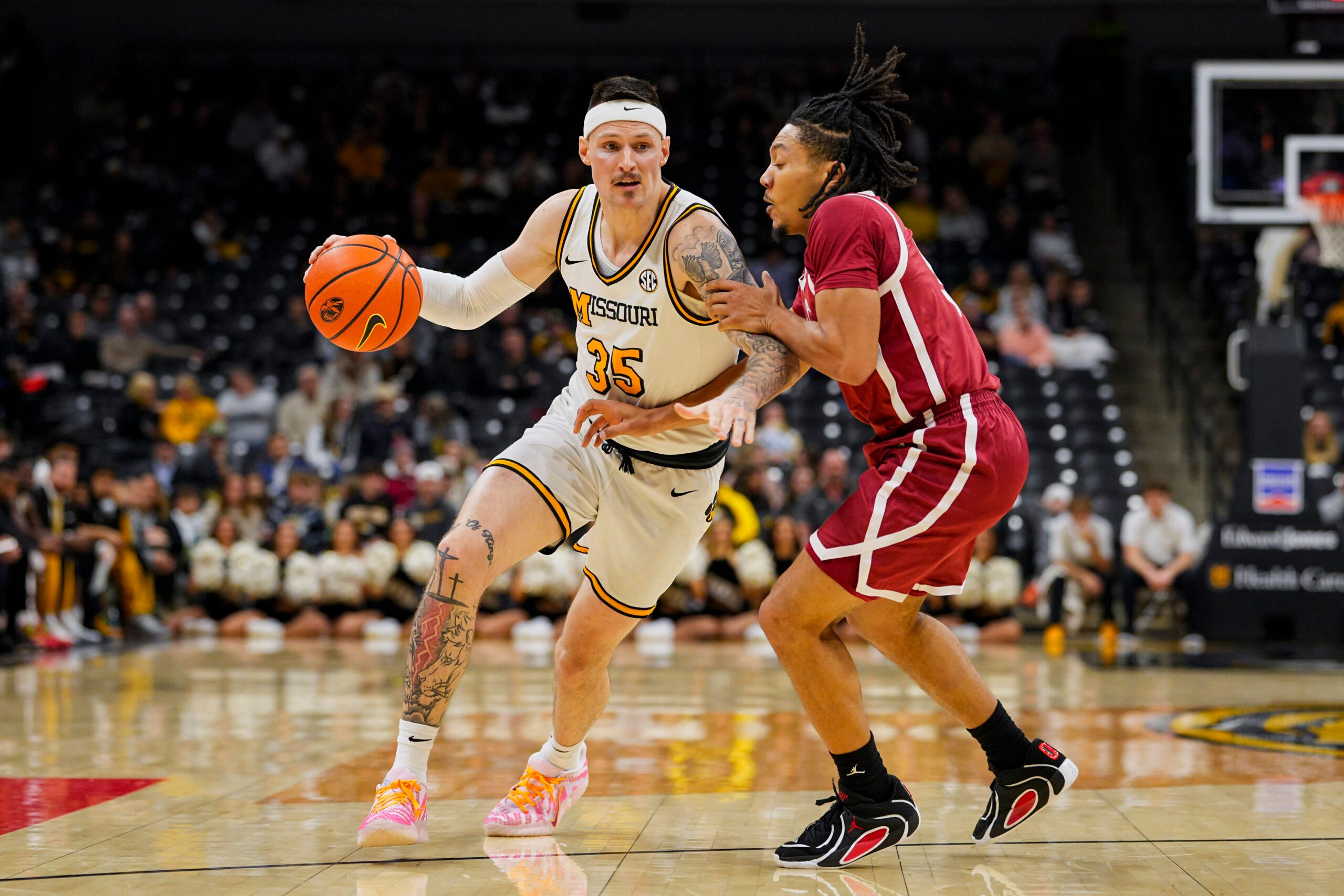 Jan 24, 2026; Columbia, Missouri, USA; Missouri Tigers guard Jacob Crews (35) drives against Oklahoma Sooners guard Nijel Pack (9) during the first half at Mizzou Arena. Mandatory Credit: Jay Biggerstaff-Imagn Images
