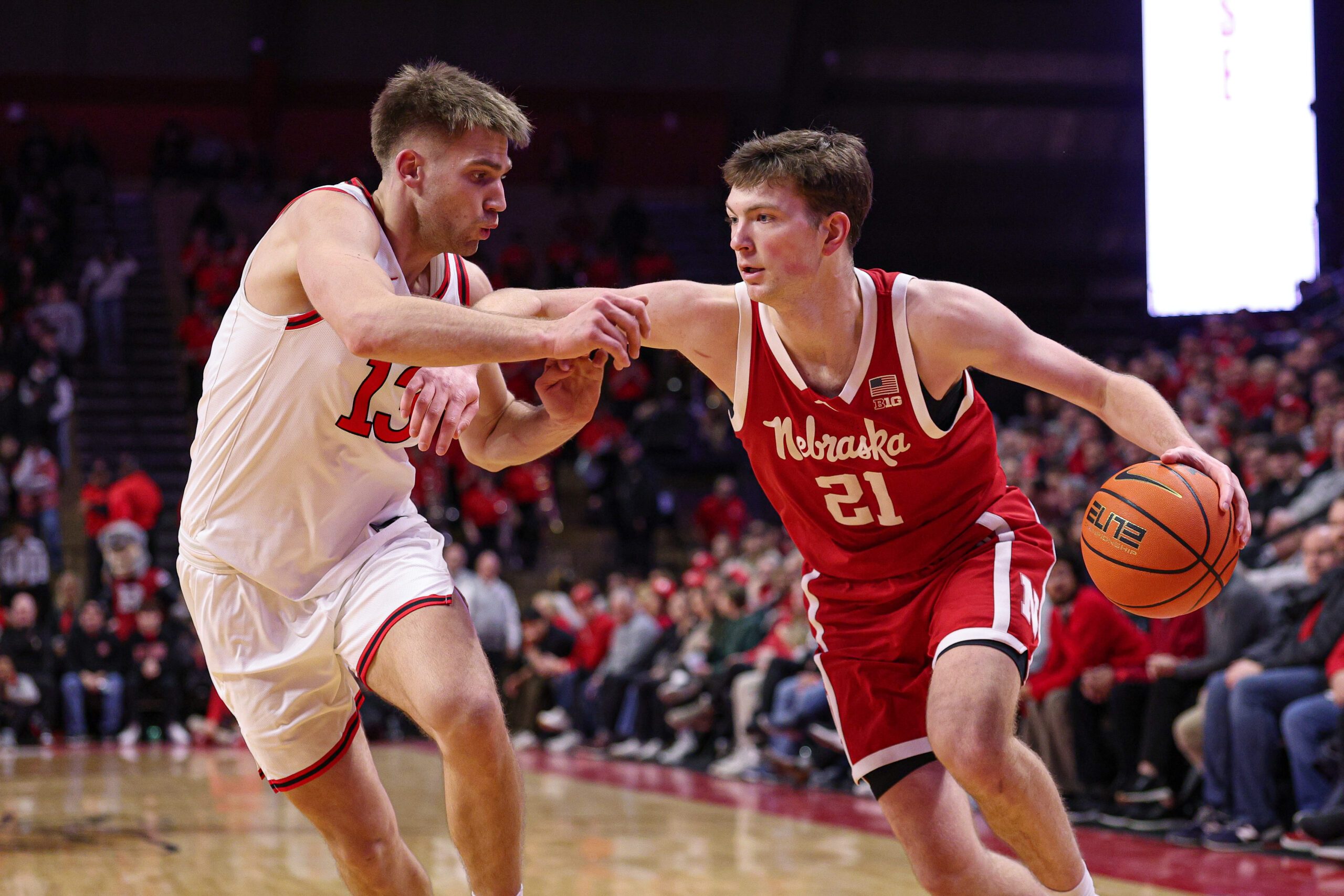 Feb 7, 2026; Piscataway, New Jersey, USA; Nebraska Cornhuskers forward Pryce Sandfort (21) is guarded by Rutgers Scarlet Knights guard Harun Zrno (13) during the first half at Jersey Mike's Arena. Mandatory Credit: Vincent Carchietta-Imagn Images