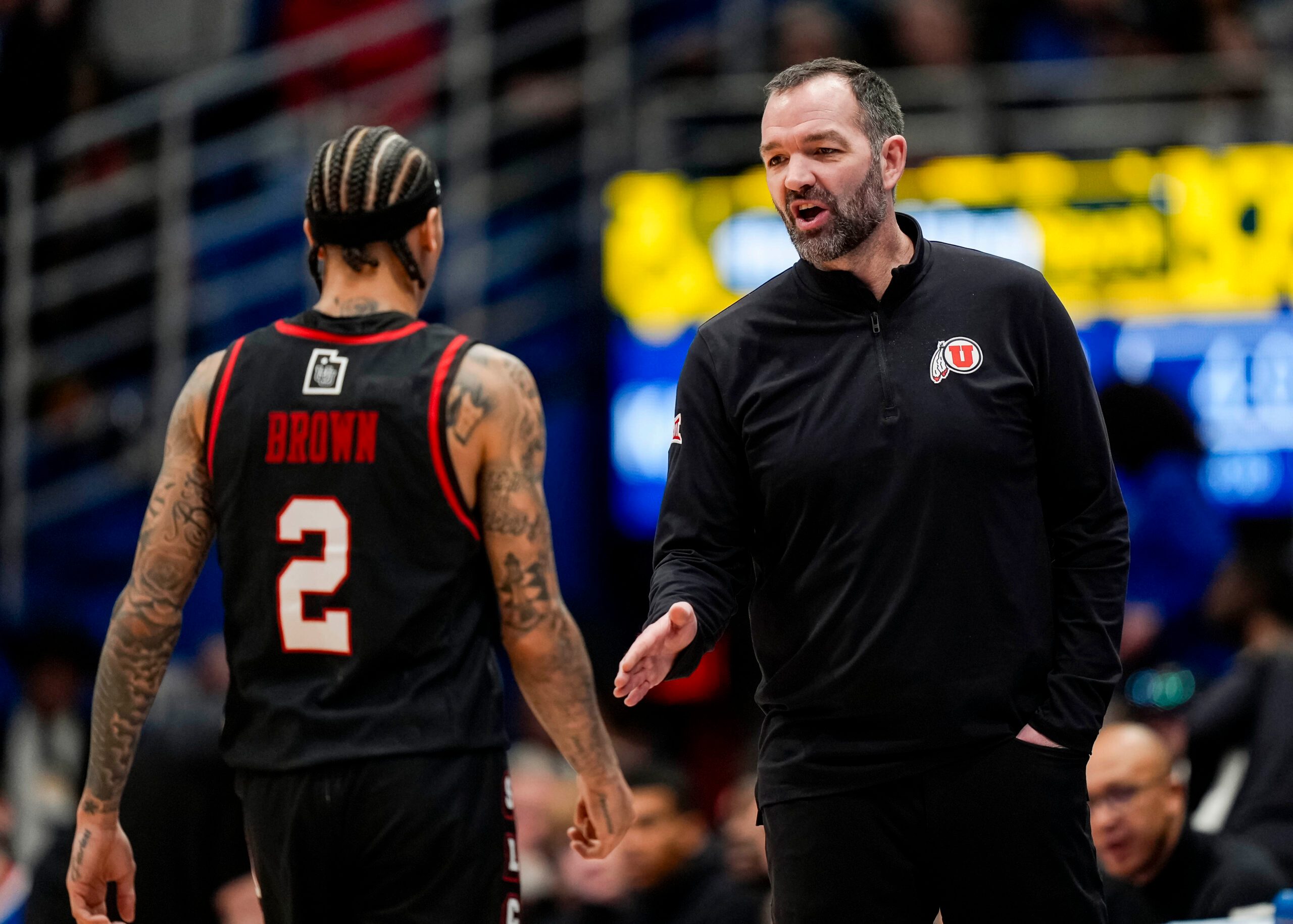 Feb 7, 2026; Lawrence, Kansas, USA; Utah Utes head coach Alex Jensen talks with guard Terrence Brown (2) during the first half against the Utah Utes at Allen Fieldhouse. Mandatory Credit: Jay Biggerstaff-Imagn Images