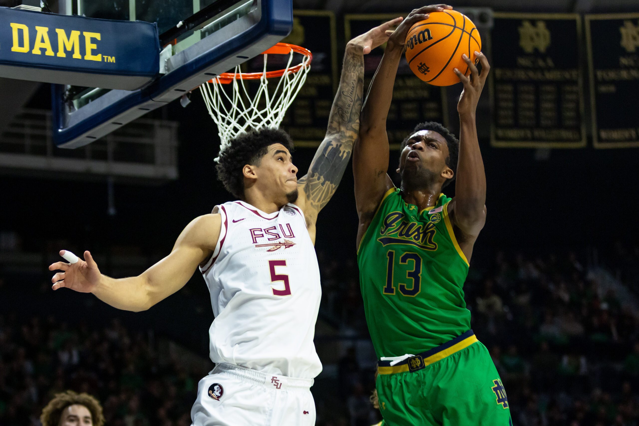 Feb 7, 2026; South Bend, Indiana, USA; Notre Dame Fighting Irish guard Sir Mohammed (13) and Florida State Seminoles guard Kobe Magee (5) fight for a rebound during the second half at Purcell Pavilion at the Joyce Center. Mandatory Credit: Michael Caterina-Imagn Images