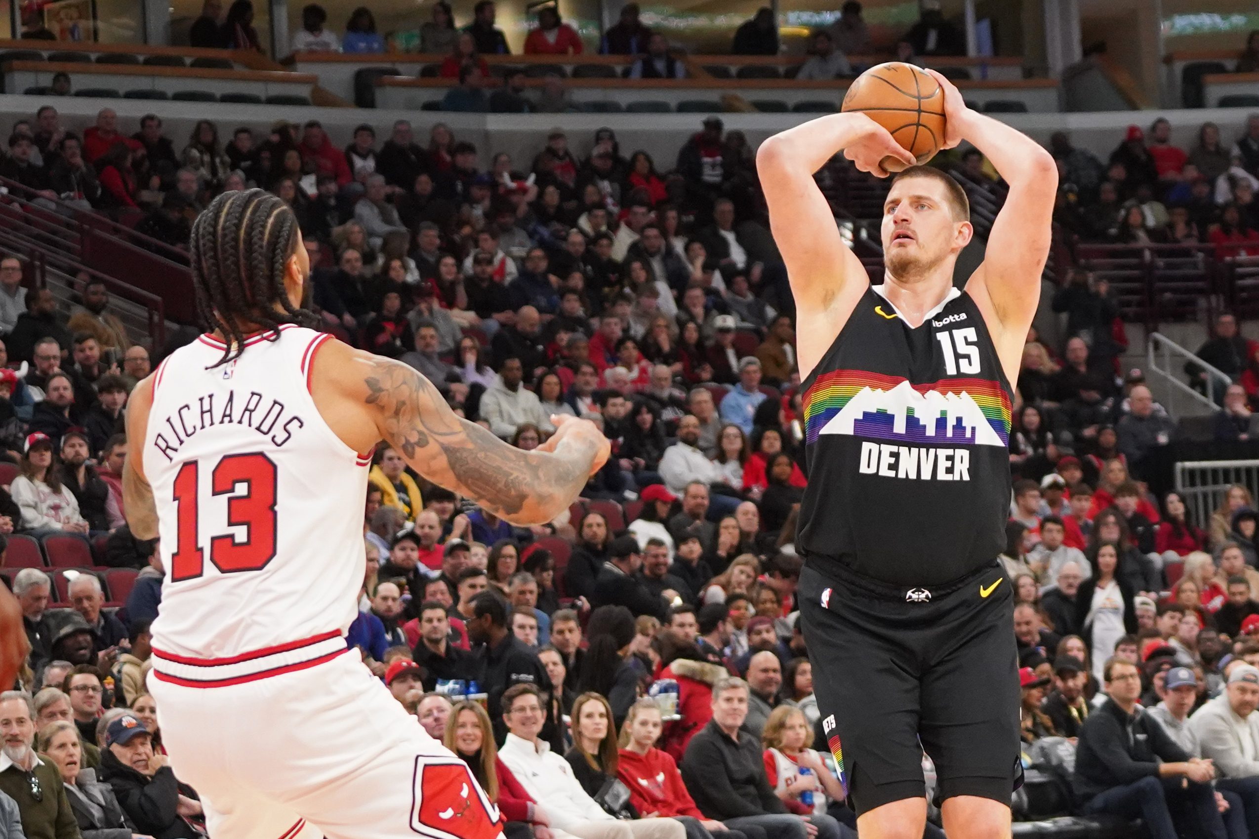 Feb 7, 2026; Chicago, Illinois, USA; Denver Nuggets center Nikola Jokic (15) makes a three point basket over Chicago Bulls center Nick Richards (13) during the first half at United Center. Mandatory Credit: David Banks-Imagn Images