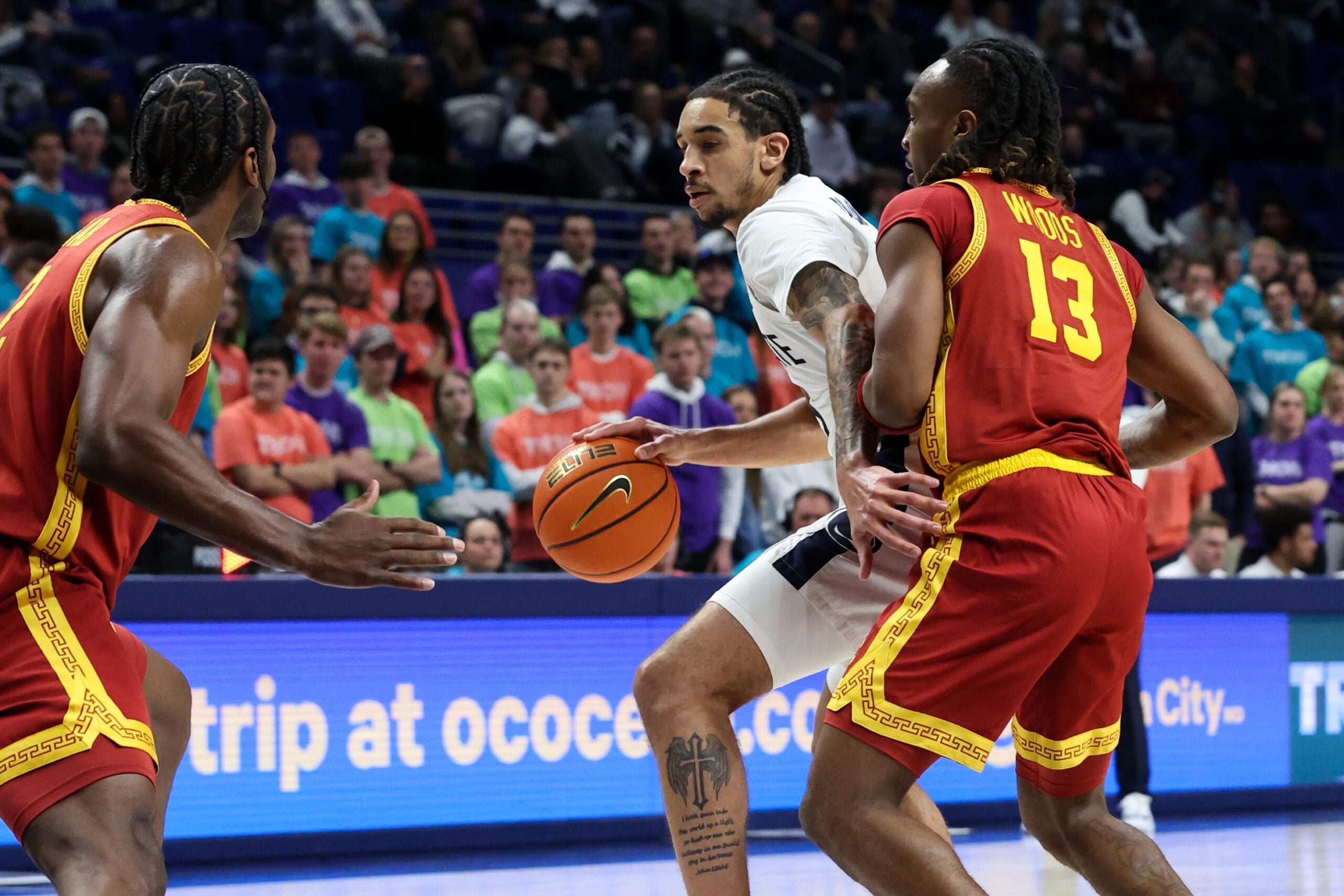 Feb 8, 2026; University Park, Pennsylvania, USA; Penn State Nittany Lions guard Freddie Dilione V (5) looks for an open lane to the basket as Southern California Trojans guard Kam Woods (13) and forward Ezra Ausar (2) defend during the first half at Bryce Jordan Center. Mandatory Credit: Matthew O'Haren-Imagn Images