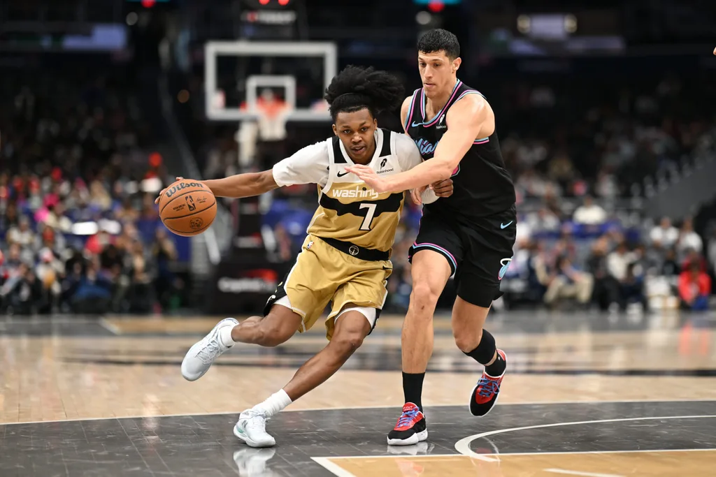 Feb 8, 2026; Washington, District of Columbia, USA; Washington Wizards guard Bub Carrington (7) attempts to dibble past Miami Heat forward Simone Fontecchio (0) during the fourth quarter at Capital One Arena. Mandatory Credit: Rafael Suanes-Imagn Images