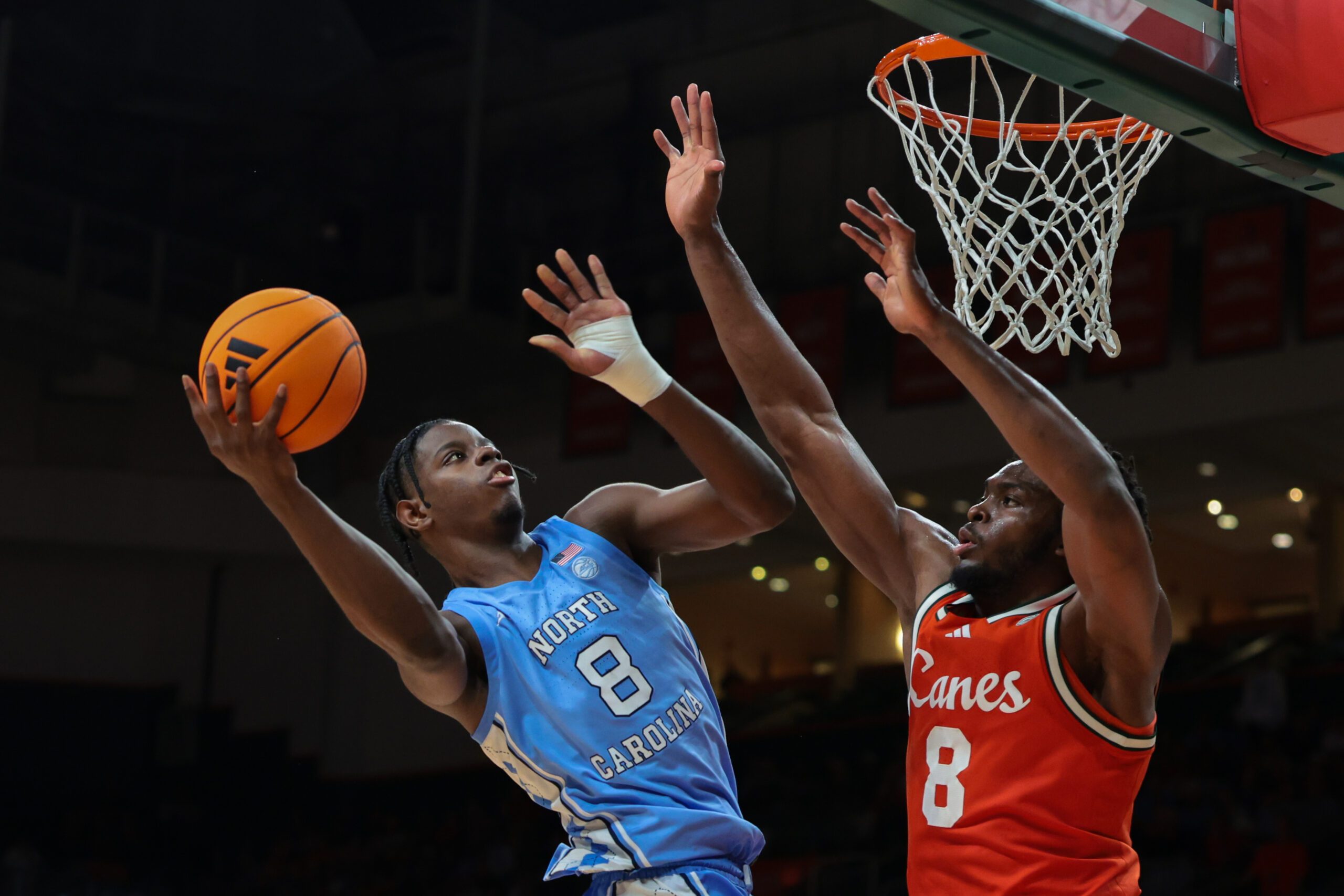 Feb 10, 2026; Coral Gables, Florida, USA; North Carolina Tar Heels forward Caleb Wilson (8) drives to the basket against Miami Hurricanes center Ernest Udeh Jr. (8) during the second half at Watsco Center. Mandatory Credit: Sam Navarro-Imagn Images