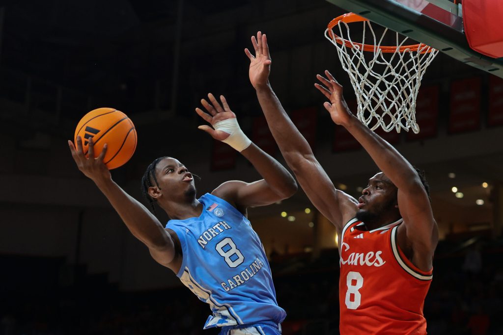 Feb 10, 2026; Coral Gables, Florida, USA; North Carolina Tar Heels forward Caleb Wilson (8) drives to the basket against Miami Hurricanes center Ernest Udeh Jr. (8) during the second half at Watsco Center. Mandatory Credit: Sam Navarro-Imagn Images