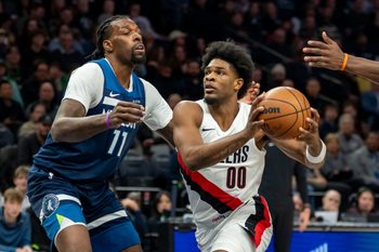 Feb 11, 2026; Minneapolis, Minnesota, USA; Portland Trail Blazers guard Scoot Henderson (00) drives to the basket past Minnesota Timberwolves center Naz Reid (11) in the first half at Target Center. Mandatory Credit: Jesse Johnson-Imagn Images