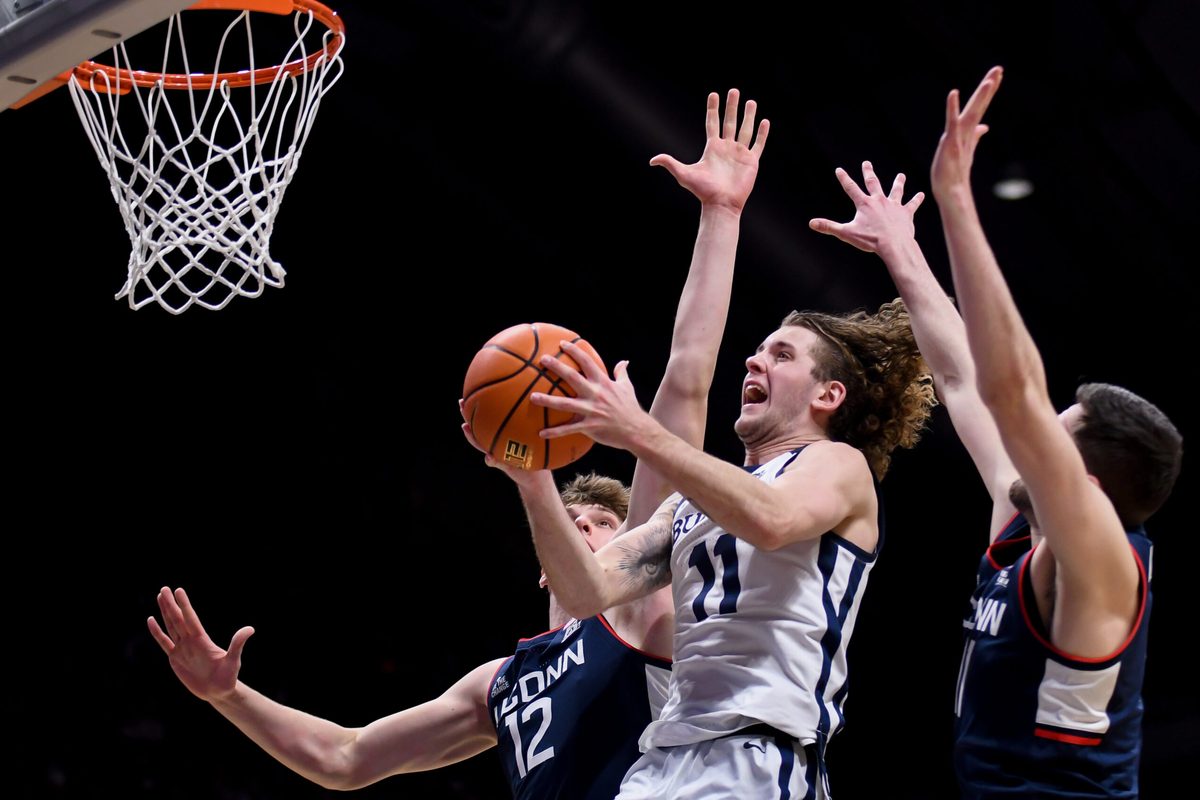 Feb 11, 2026; Indianapolis, Indiana, USA; Butler Bulldogs guard Finley Bizjack (11) shoots past UConn Huskies center Eric Reibe (12) during the second half at Hinkle Fieldhouse. Mandatory Credit: Robert Goddin-Imagn Images