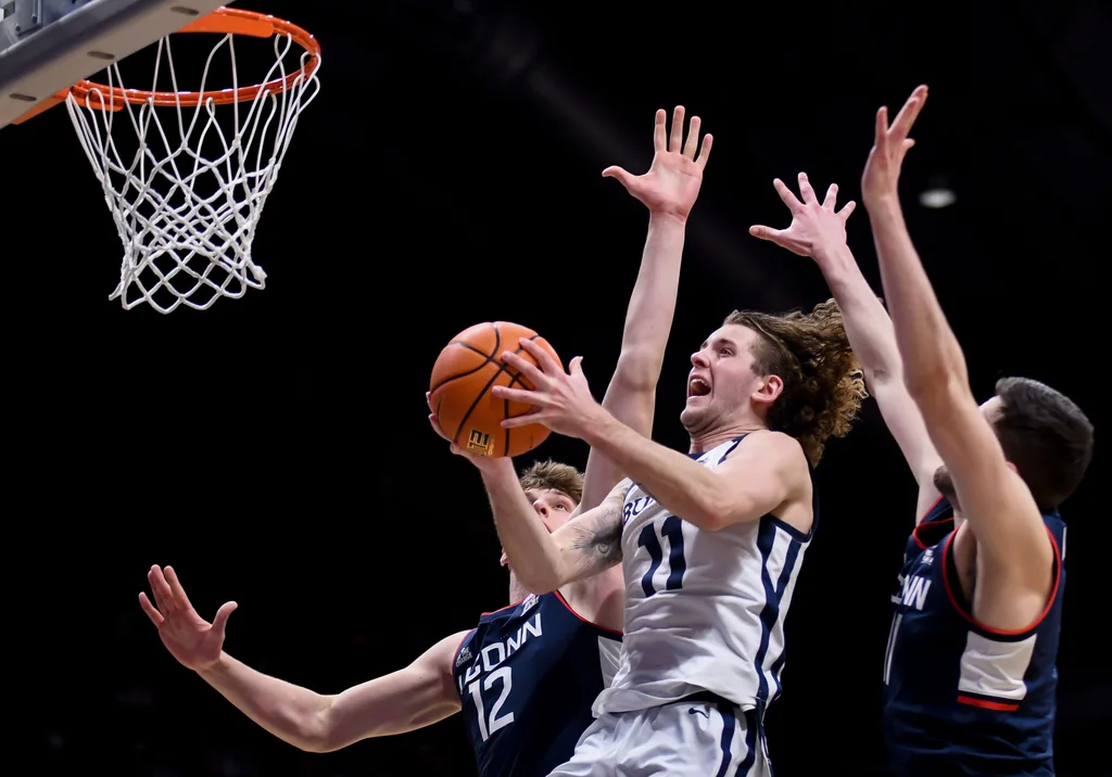 Feb 11, 2026; Indianapolis, Indiana, USA; Butler Bulldogs guard Finley Bizjack (11) shoots past UConn Huskies center Eric Reibe (12) during the second half at Hinkle Fieldhouse. Mandatory Credit: Robert Goddin-Imagn Images