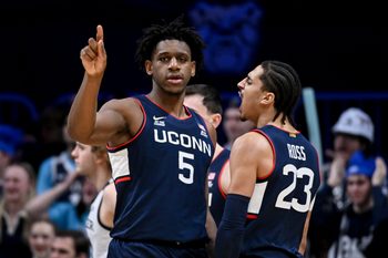 Feb 11, 2026; Indianapolis, Indiana, USA; UConn Huskies center Tarris Reed Jr. (5) celebrates with UConn Huskies forward Jayden Ross (23) against the Butler Bulldogs during the second half at Hinkle Fieldhouse. Mandatory Credit: Robert Goddin-Imagn Images
