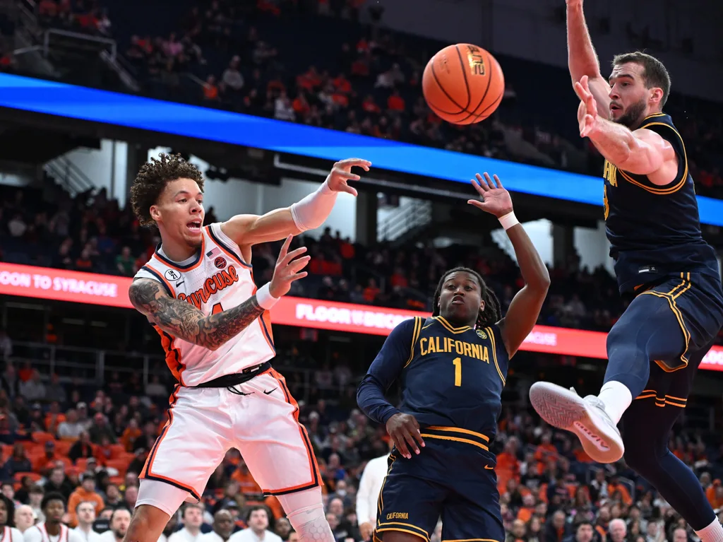 Feb 11, 2026; Syracuse, New York, USA; Syracuse Orange guard Nate Kingz (4) passes the ball as California Golden Bears center Milos Ilic (8) and guard Dejuan Campbell (1) defend in the second half at the JMA Wireless Dome. Mandatory Credit: Mark Konezny-Imagn Images