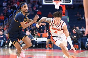 Feb 11, 2026; Syracuse, New York, USA; Syracuse Orange guard Nate Kingz (4) drives past California Golden Bears forward Chris Bell (22) in the second half at the JMA Wireless Dome. Mandatory Credit: Mark Konezny-Imagn Images