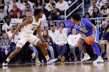 Feb 14, 2026; Ann Arbor, Michigan, USA; UCLA Bruins guard Skyy Clark (55) is defended by Michigan Wolverines forward Morez Johnson Jr. (21) in the first half at Crisler Center. Mandatory Credit: Rick Osentoski-Imagn Images