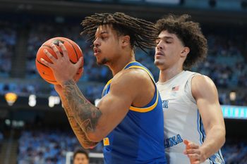 Feb 14, 2026; Chapel Hill, North Carolina, USA; Pittsburgh Panthers forward Cameron Corhen (2) with the ball as North Carolina Tar Heels forward Zayden High (1) defends in the first half at Dean E. Smith Center. Mandatory Credit: Bob Donnan-Imagn Images