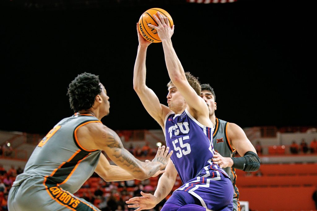 Feb 14, 2026; Stillwater, Oklahoma, USA; TCU Horned Frogs guard Tanner Toolson (55) drives to the basket around Oklahoma State Cowboys guard Anthony Roy (9) during the second half at Gallagher-Iba Arena. Mandatory Credit: William Purnell-Imagn Images
