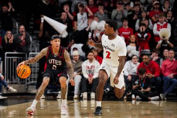 Feb 15, 2026; Cincinnati, Ohio, USA;  Utah Utes guard Terrence Brown (2) dribbles the ball against Cincinnati Bearcats guard Jizzle James (2) in the second at Fifth Third Arena. Mandatory Credit: Aaron Doster-Imagn Images