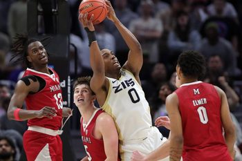 Akron Zips forward Amani Lyles grabs a rebound over Miami guard Peter Suder (5) during the Mid-American Conference Tournament championship game March 15, 2025, in Cleveland.