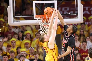 Feb 16, 2026; Ames, Iowa, USA; Houston Cougars guard Mercy Miller (25) dunks over Iowa State Cyclones forward Dominykas Pleta (21) during the first half at James H. Hilton Coliseum. Mandatory Credit: Reese Strickland-Imagn Images