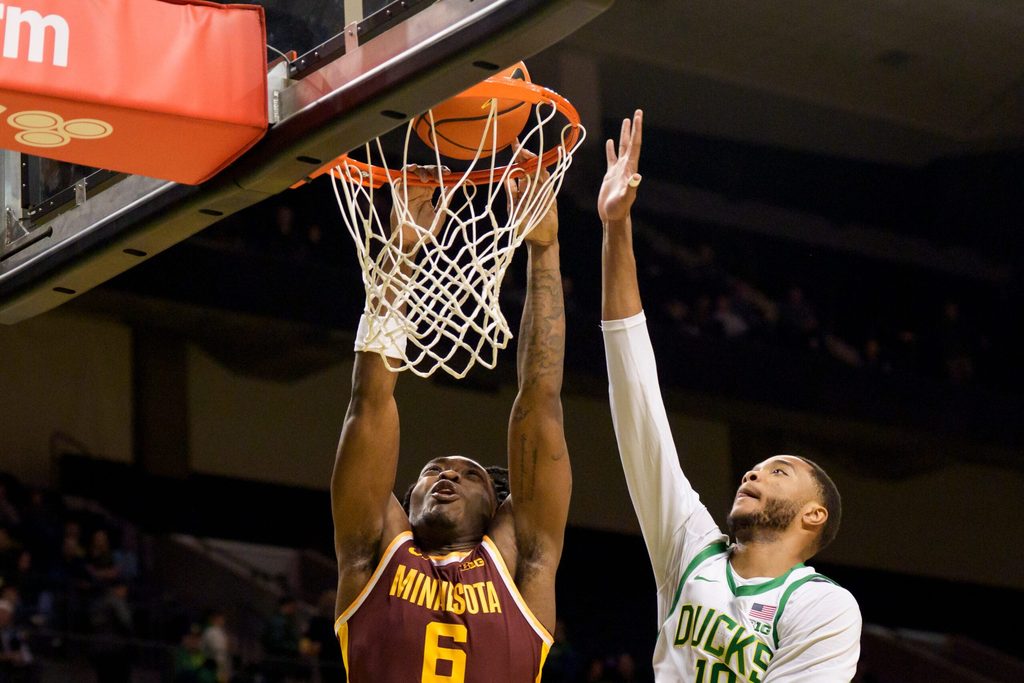 Minnesota guard Langston Reynolds, left, dunks under cover from Oregon forward Kwame Evans Jr. as the Oregon Ducks host the Minnesota Golden Gophers on Feb. 17, 2026, at Matthew Knight Arena in Eugene, Oregon.