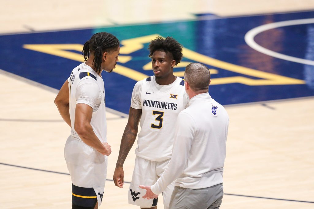 Feb 18, 2026; Morgantown, West Virginia, USA; West Virginia Mountaineers head coach Ross Hodge talks with guard Jasper Floyd (1) and guard Honor Huff (3) during the second half against the Utah Utes at Hope Coliseum. Mandatory Credit: Ben Queen-Imagn Images