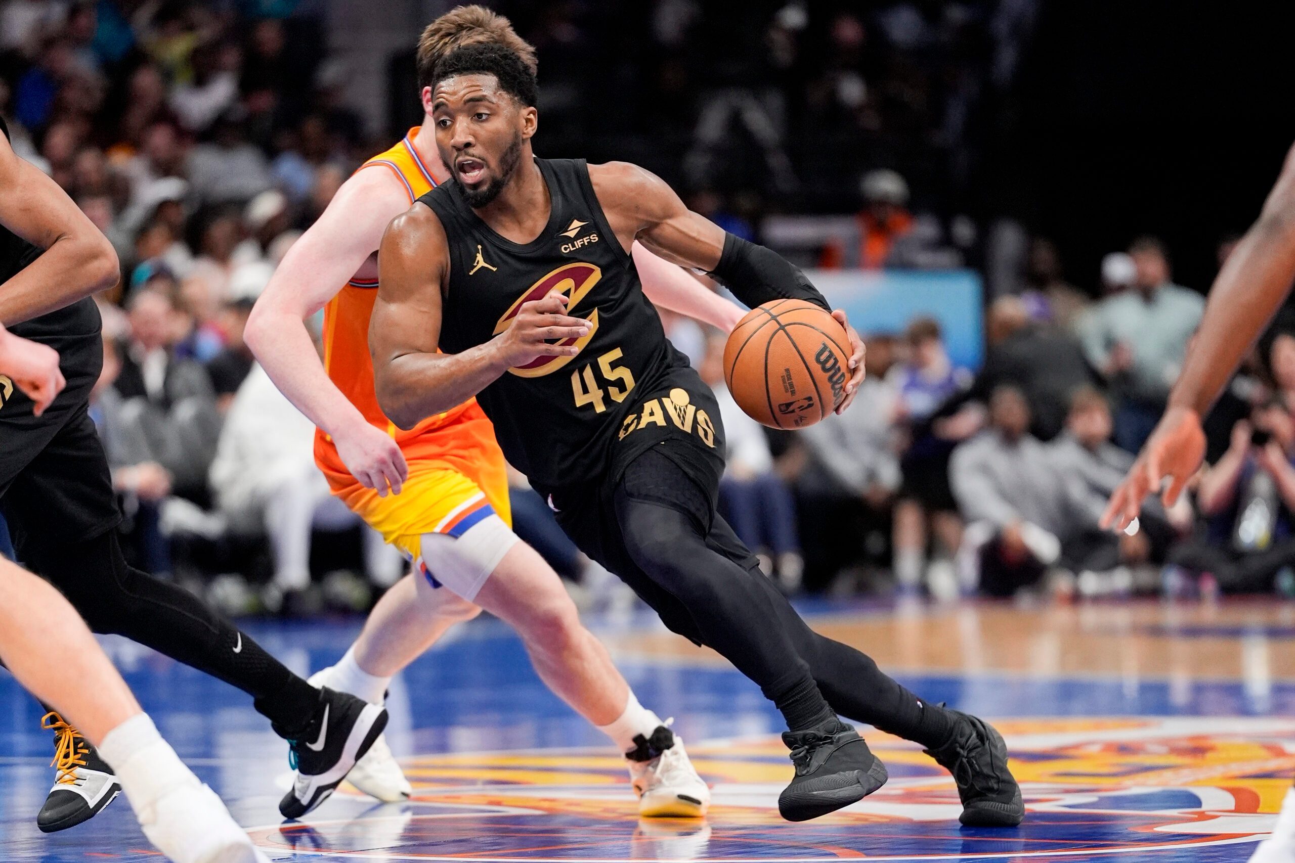 Feb 20, 2026; Charlotte, North Carolina, USA; Cleveland Cavaliers guard Donovan Mitchell (45) drives against Charlotte Hornets guard Kon Knueppel (7) during the second half at the Spectrum Center. Mandatory Credit: Jim Dedmon-Imagn Images