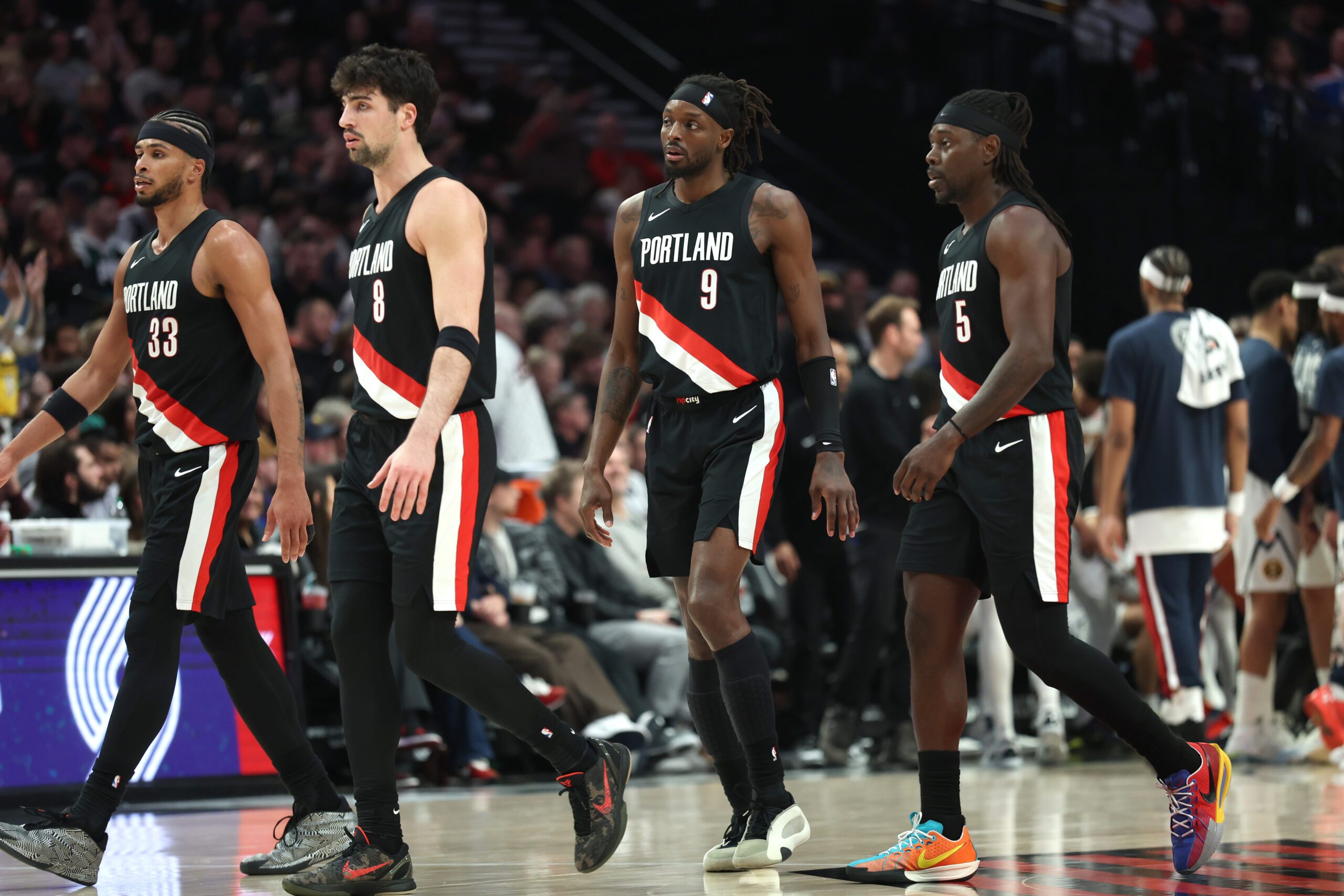 Feb 20, 2026; Portland, Oregon, USA;  Portland Trail Blazers forward Toumani Camara (33), forward Deni Avdija (8), forward Jerami Grant (9) and guard Jrue Holiday (5) walk toward the bench in frustration during the second half against the Denver Nuggets at Moda Center. Mandatory Credit: Jaime Valdez-Imagn Images