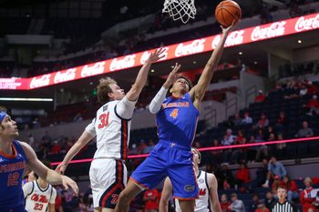 Feb 21, 2026; Oxford, Mississippi, USA; Florida Gators guard Alex Lloyd (4) shoots as Mississippi Rebels guard Zach Day (31) defends during the second half at The Sandy and John Black Pavilion at Ole Miss. Mandatory Credit: Petre Thomas-Imagn Images