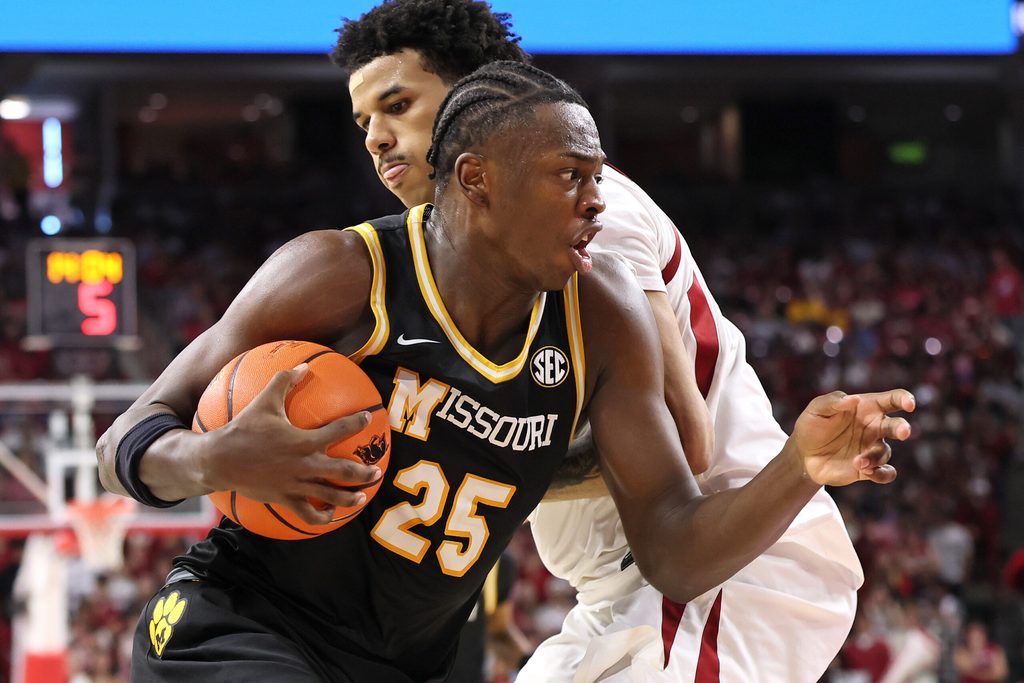 Feb 21, 2026; Fayetteville, Arkansas, USA; Missouri Tigers guard Mark Mitchell (25) drives against Arkansas Razorbacks forward Malique Ewin (12) during the second half at Bud Walton Arena. Arkansas won 94-86. Mandatory Credit: Nelson Chenault-Imagn Images