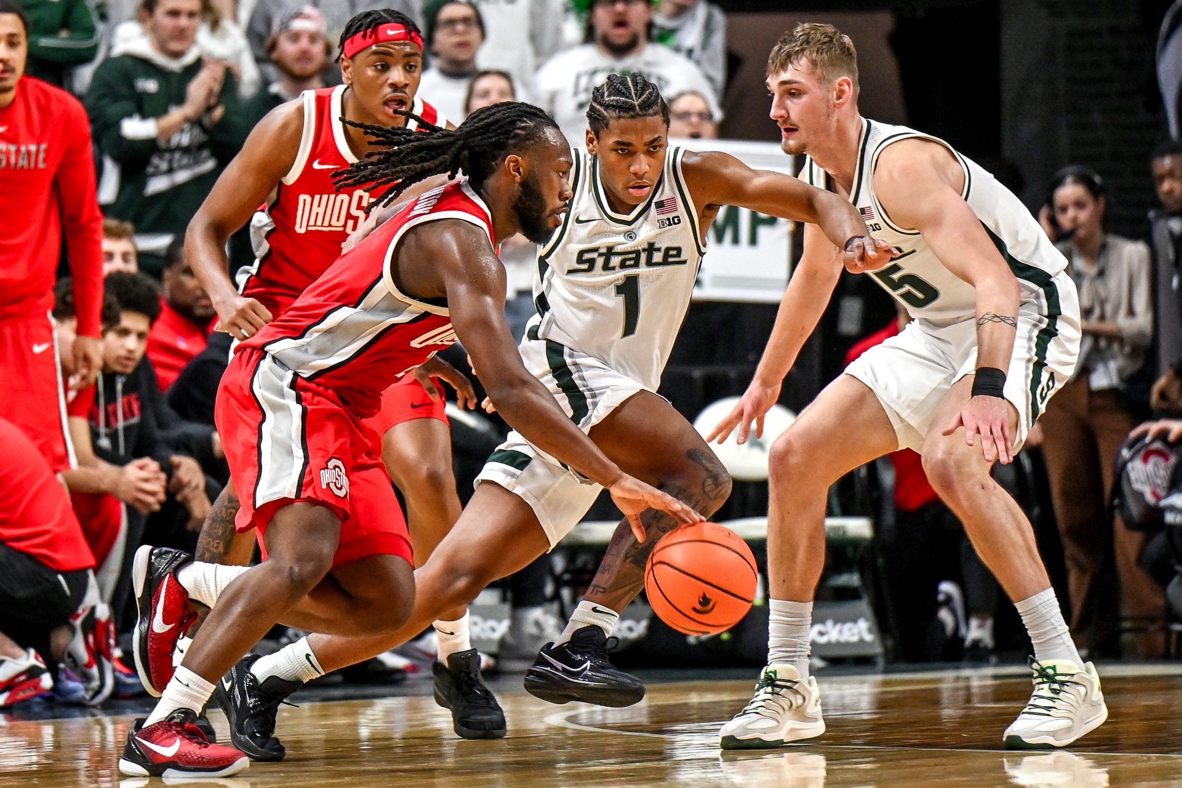Michigan State's Jeremy Fears Jr., center, defends against Ohio State's Bruce Thornton, left, during the second half on Sunday, Feb. 22, 2026, at the Breslin Center in East Lansing.
