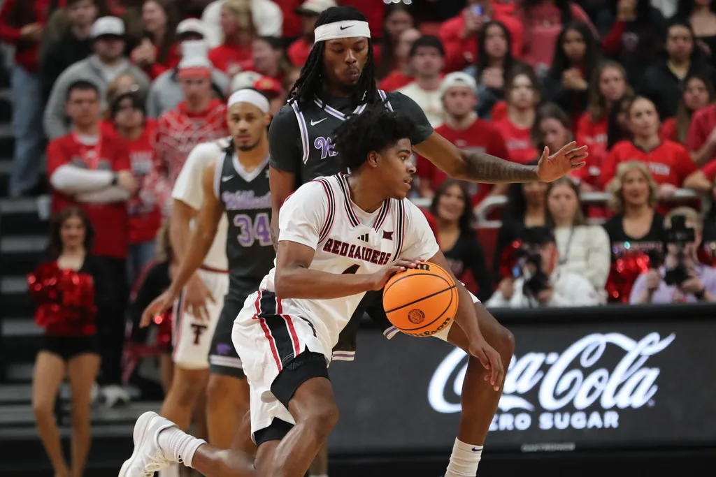 Feb 21, 2026; Lubbock, Texas, USA; Texas Tech Red Raiders guard Christian Anderson (4) drives the ball around Kansas State Wildcats guard C.J. Jones (3) in the first half at United Supermarkets Arena. Mandatory Credit: Michael C. Johnson-Imagn Images