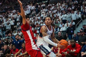 Feb 25, 2026; Hartford, Connecticut, USA; UConn Huskies guard Solo Ball (1) looks for an opening against St. John's Red Storm guard Oziyah Sellers (4) in the first half at PeoplesBank Arena. Mandatory Credit: David Butler II-Imagn Images