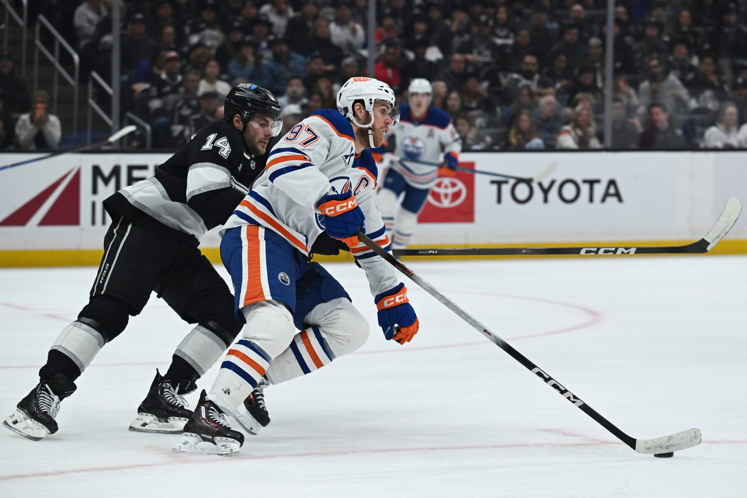 Feb 26, 2026; Los Angeles, California, USA; Edmonton Oilers center Connor McDavid (97) and Los Angeles Kings right wing Alex Laferriere (14) battle for the puck during the second period at Crypto.com Arena. Mandatory Credit: Griffin Hooper-Imagn Images