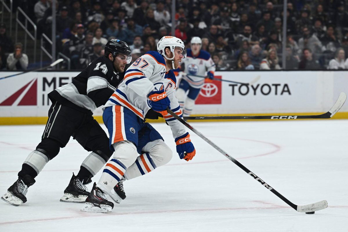 Feb 26, 2026; Los Angeles, California, USA; Edmonton Oilers center Connor McDavid (97) and Los Angeles Kings right wing Alex Laferriere (14) battle for the puck during the second period at Crypto.com Arena. Mandatory Credit: Griffin Hooper-Imagn Images