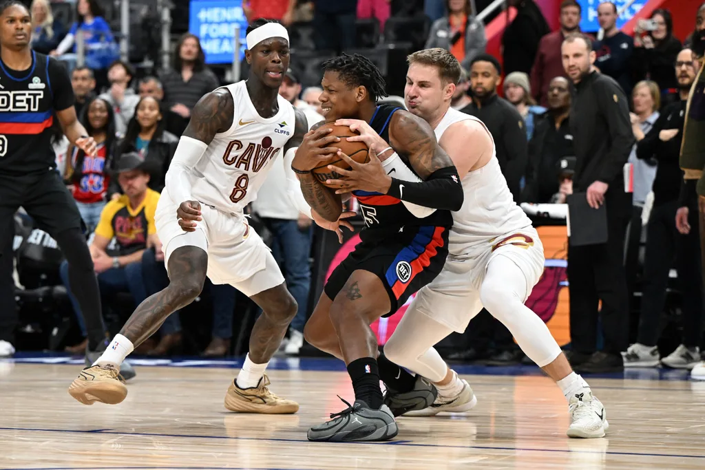 Feb 27, 2026; Detroit, Michigan, USA; Cleveland Cavaliers guard Sam Merrill (5) ties up Detroit Pistons guard Marcus Sasser (25) for a jump ball as Cleveland Cavaliers guard Dennis Schroder (8) looks on in overtime at Little Caesars Arena. Mandatory Credit: Lon Horwedel-Imagn Images