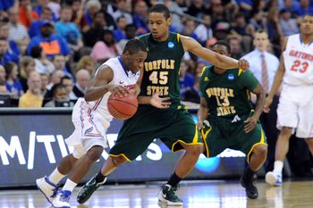 Mar 18, 2012; Omaha, NE, USA; Florida Gators guard Erving Walker (11) drives against Norfolk State Spartans forward A.J. Rogers (45) during the second half in the third round of the 2012 NCAA men's basketball tournament at the CenturyLink Center.  Florida defeated Norfolk State 84-50.  Mandatory Credit: Peter G. Aiken-Imagn Images