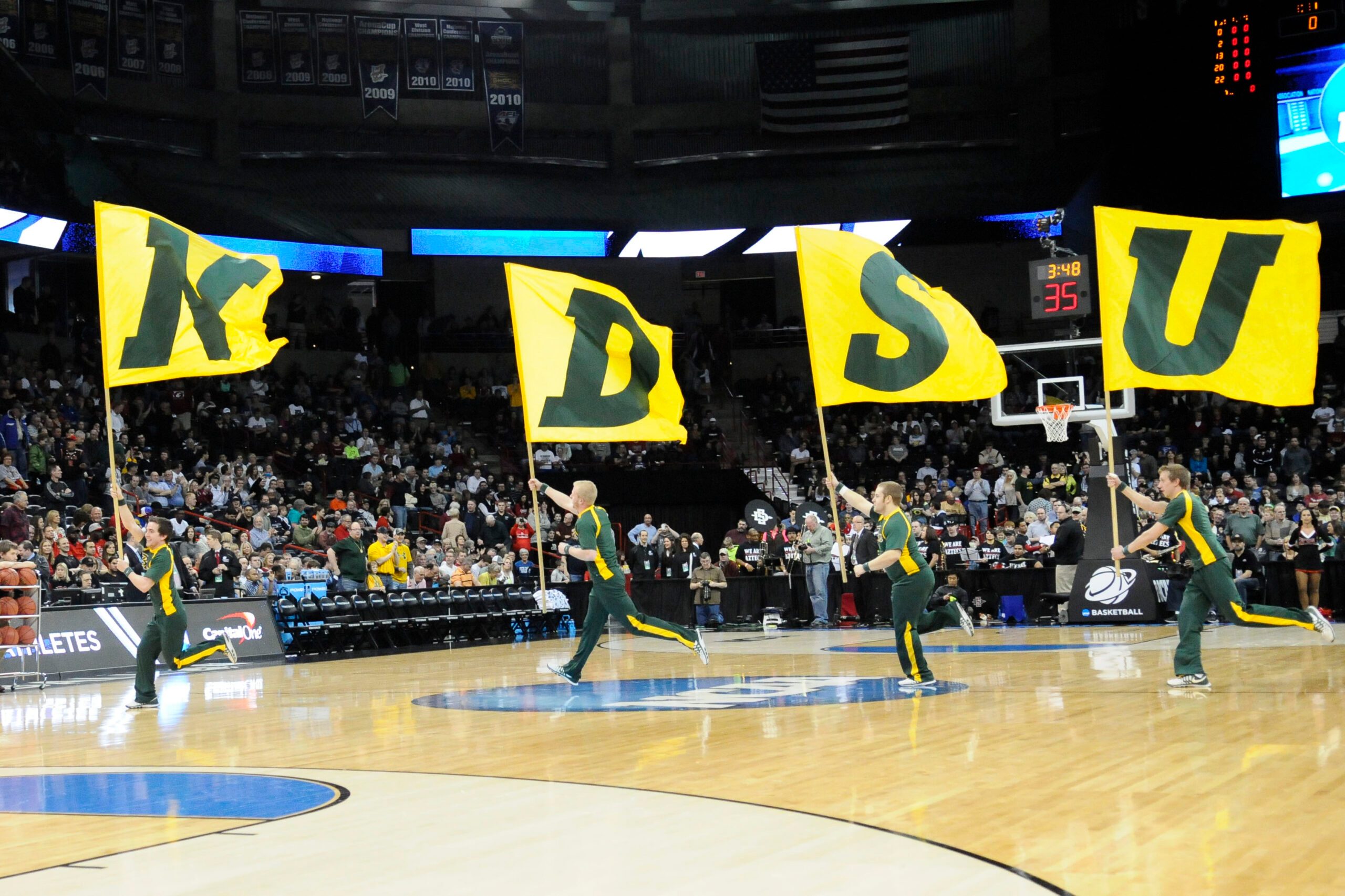 Mar 22, 2014; Spokane, WA, USA; North Dakota State Bison cheerleaders run across court with flags before a men's college basketball game during the third round of the 2014 NCAA Tournament against the San Diego State Aztecs at Veterans Memorial Arena. Mandatory Credit: James Snook-Imagn Images