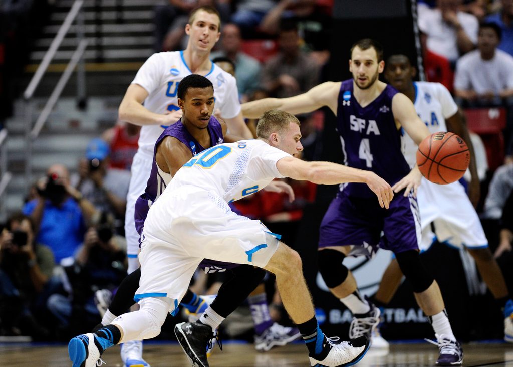 Mar 23, 2014; San Diego, CA, USA; UCLA Bruins guard Bryce Alford (20) passes the ball away from Stephen F. Austin Lumberjacks guard Trey Pinkney in the second half of a men's college basketball game during the third round of the 2014 NCAA Tournament at Viejas Arena. Mandatory Credit: Robert Hanashiro-Imagn Images