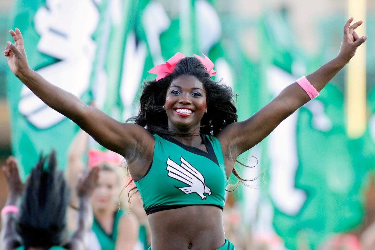 Oct 18, 2014; Denton, TX, USA; North Texas Mean Green cheerleader runs onto the field prior to the game vs Southern Miss Golden Eagles at Apogee Stadium. Southern Miss won 30-20. Mandatory Credit: Ray Carlin-Imagn Images