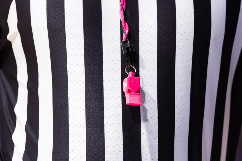 Jan 24, 2024; Gainesville, Florida, USA; SEC referee Joe Lindsey hangs a pink breast cancer awareness whistle around his neck during the first half between the Florida Gators and the Mississippi State Bulldogs at Exactech Arena at the Stephen C. O'Connell Center. Mandatory Credit: Matt Pendleton-Imagn Images