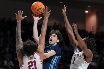 March 9, 2024; Las Vegas, NV, USA; San Diego Toreros guard Dragos Lungu (7) shoots the basketball against Santa Clara Broncos forward Camaron Tongue (21) and guard Tyeree Bryan (1) during the first half in the quarterfinals of the WCC Basketball Championship at Orleans Arena. Mandatory Credit: Kyle Terada-Imagn Images