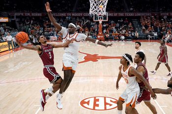 Dec 12, 2024; Austin, Texas, USA; New Mexico State Aggies guard Christian Cook (3) drives to the basket against Texas Longhorns forward Arthur Kaluma (6) during the first half at Moody Center. Mandatory Credit: Scott Wachter-Imagn Images