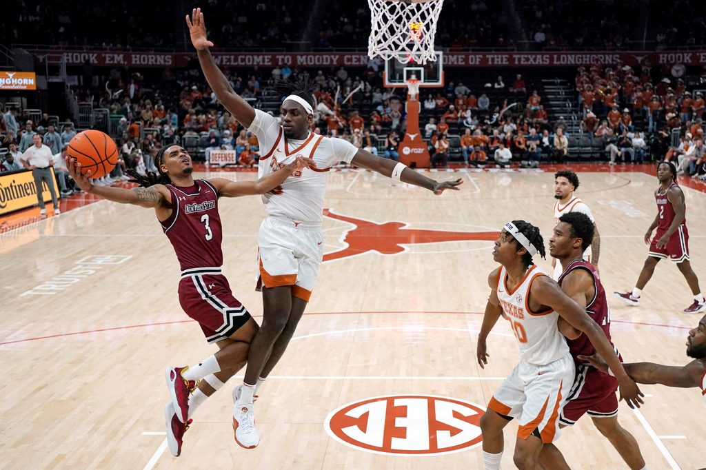 Dec 12, 2024; Austin, Texas, USA; New Mexico State Aggies guard Christian Cook (3) drives to the basket against Texas Longhorns forward Arthur Kaluma (6) during the first half at Moody Center. Mandatory Credit: Scott Wachter-Imagn Images
