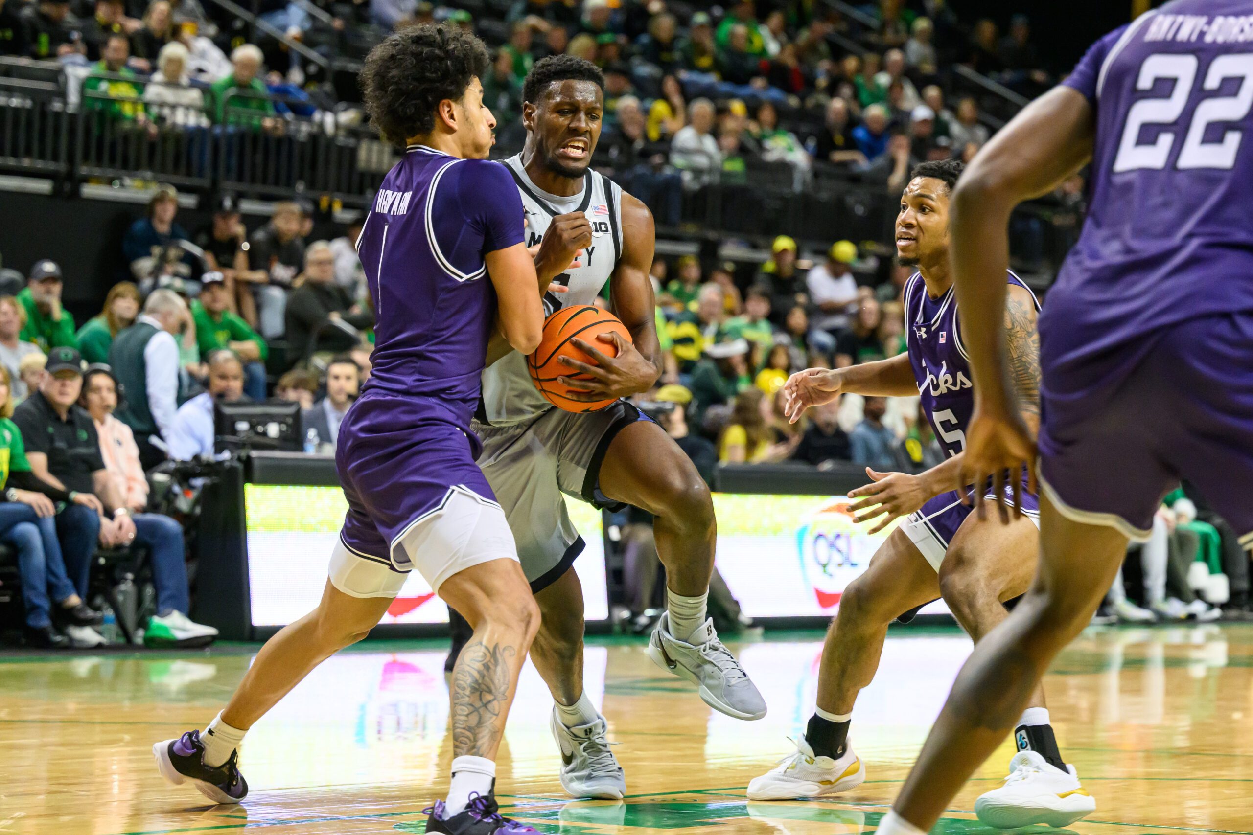 Dec 15, 2024; Eugene, Oregon, USA; Oregon Ducks guard TJ Bamba (5) drives to the basket between Stephen F. Austin Lumberjacks guard Matt Hayman (1) and guard Keon Thompson (5) during the second half at Matthew Knight Arena. Mandatory Credit: Craig Strobeck-Imagn Images