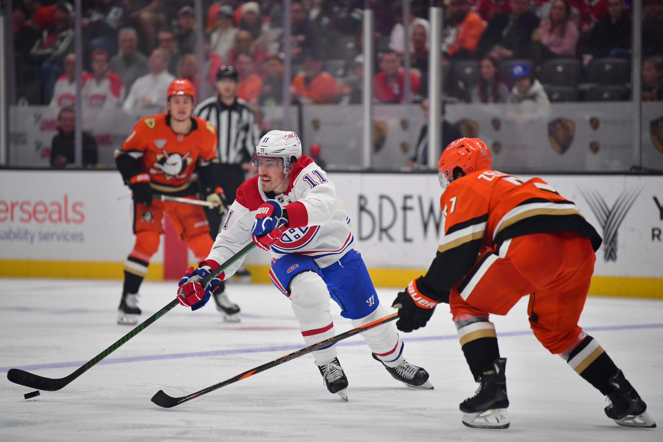 Feb 2, 2025; Anaheim, California, USA; Montreal Canadiens right wing Brendan Gallagher (11) moves the puck against Anaheim Ducks defenseman Olen Zellweger (51) during the third period at Honda Center. Mandatory Credit: Gary A. Vasquez-Imagn Images