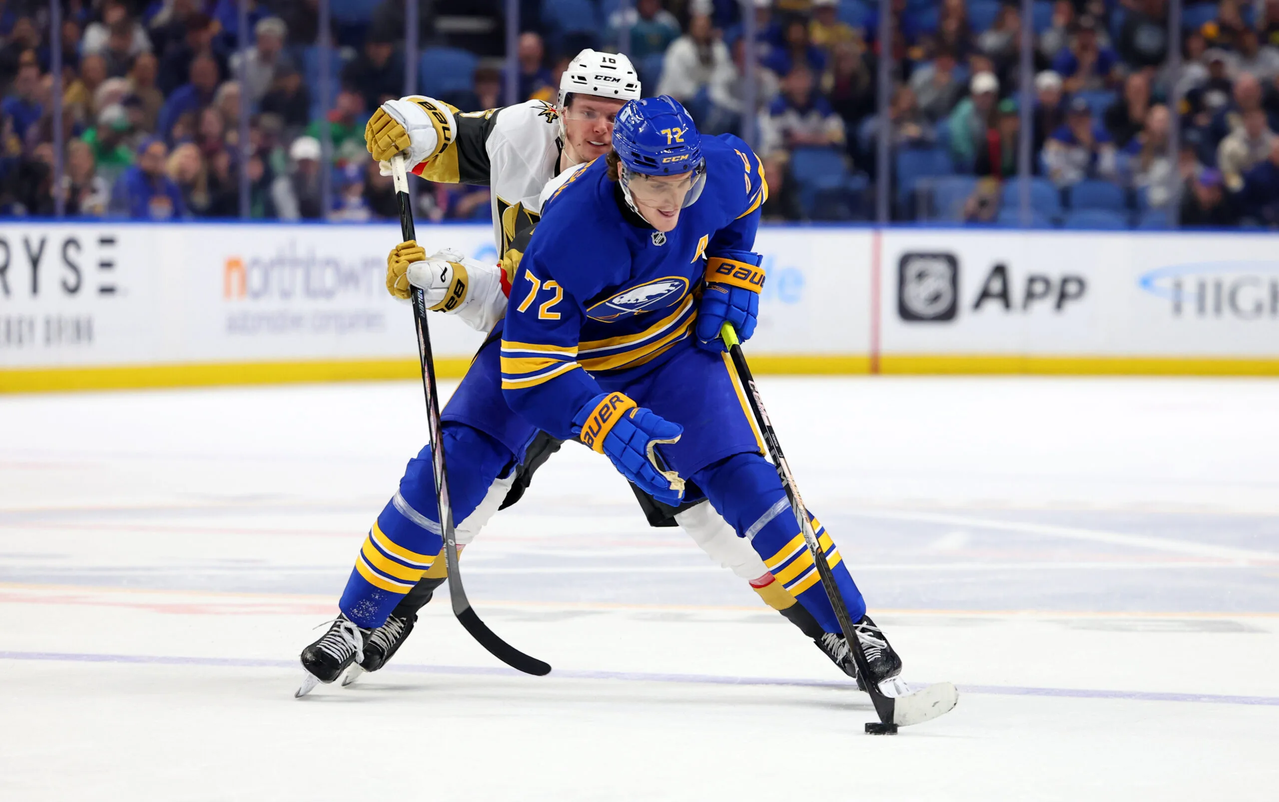 Mar 15, 2025; Buffalo, New York, USA;  Buffalo Sabres center Tage Thompson (72) skates with the puck as Vegas Golden Knights left wing Pavel Dorofeyev (16) defends during overtime at KeyBank Center. Mandatory Credit: Timothy T. Ludwig-Imagn Images