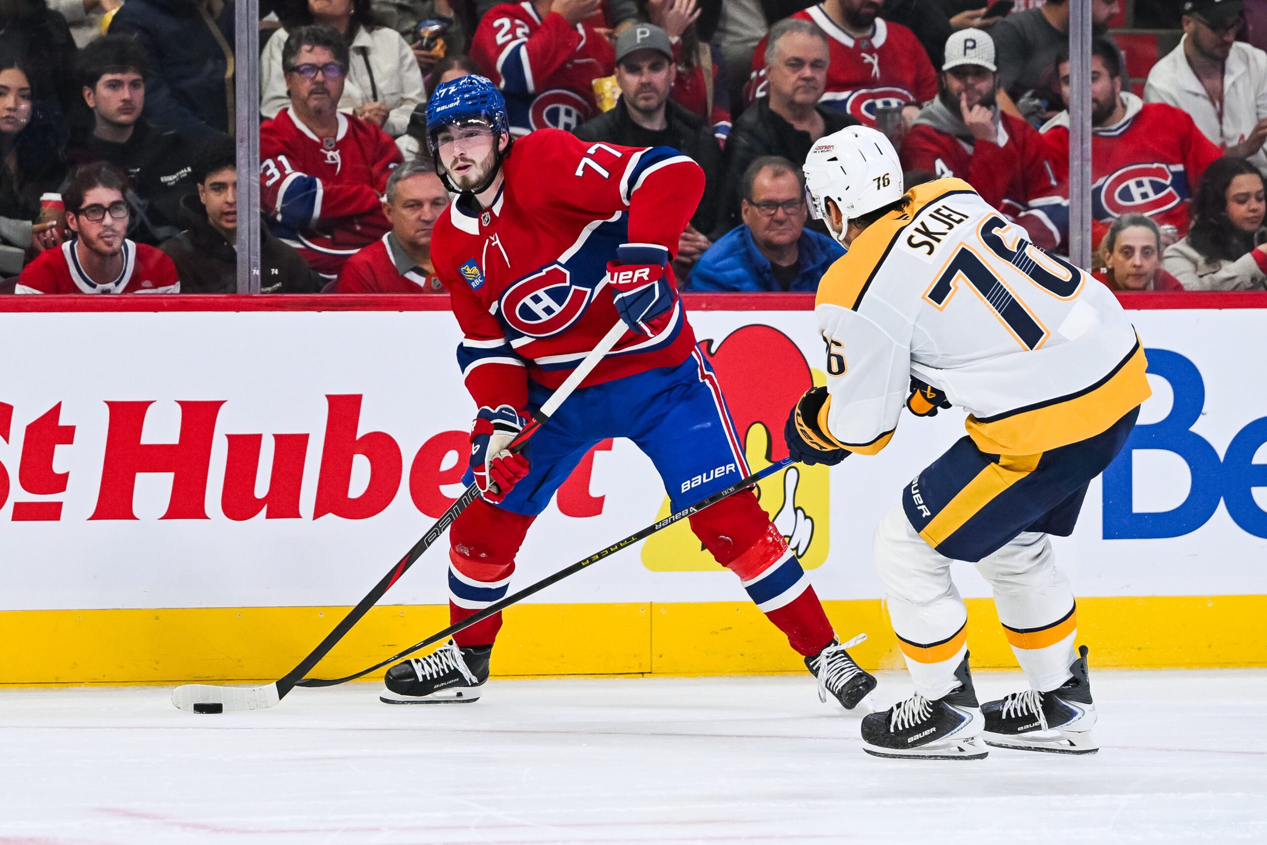 Oct 16, 2025; Montreal, Quebec, CAN; Montreal Canadiens center Kirby Dach (77) plays the puck against Nashville Predators defenseman Brady Skjei (76) during the second period at Bell Centre. Mandatory Credit: David Kirouac-Imagn Images