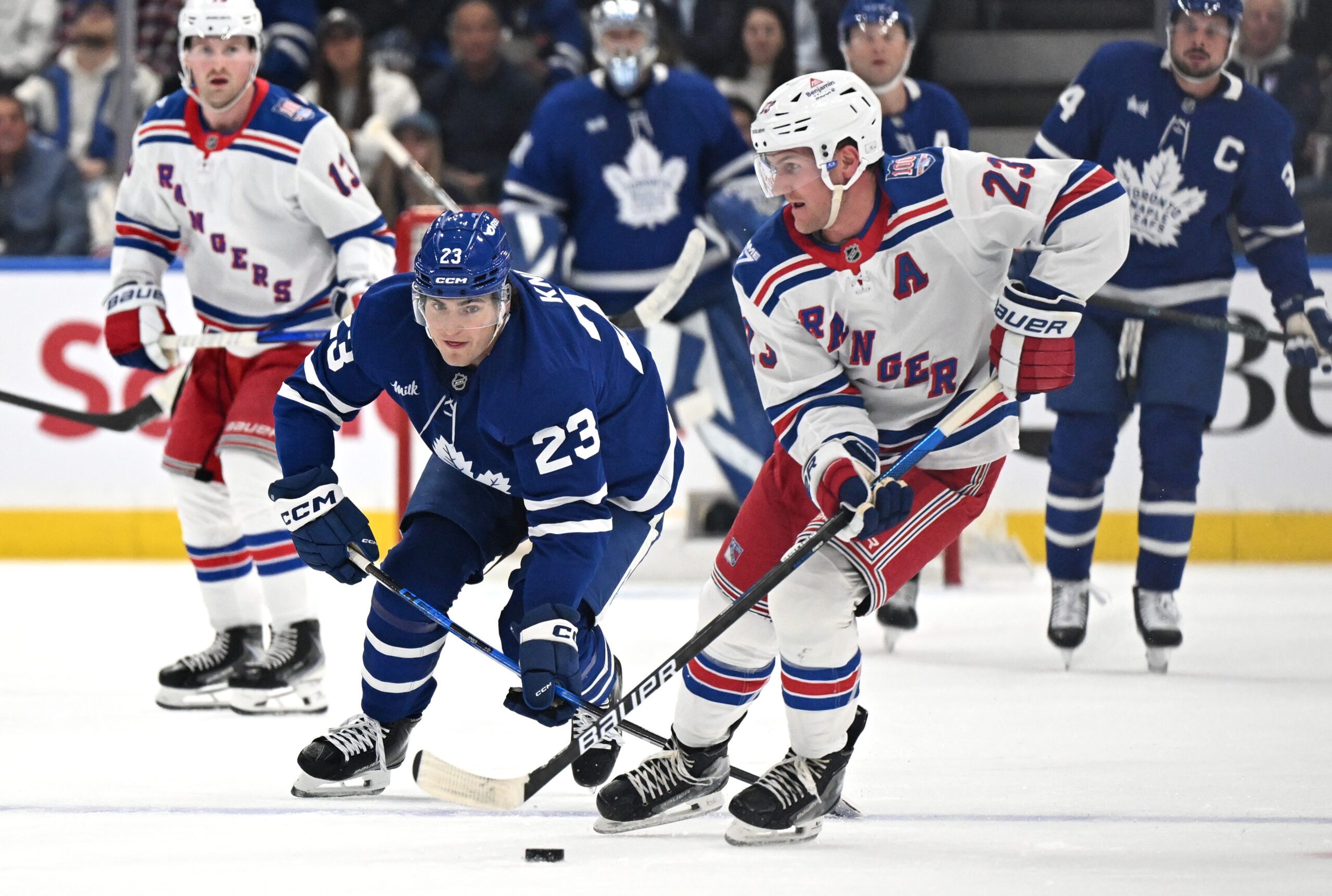 Oct 16, 2025; Toronto, Ontario, CAN; New York Rangers defenseman Adam Fox (23) moves the puck away from Toronto Maple Leafs forward Matthews Knies (23) in the first period at Scotiabank Arena. Mandatory Credit: Dan Hamilton-Imagn Images