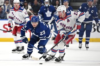 Oct 16, 2025; Toronto, Ontario, CAN; New York Rangers defenseman Adam Fox (23) moves the puck away from Toronto Maple Leafs forward Matthews Knies (23) in the first period at Scotiabank Arena. Mandatory Credit: Dan Hamilton-Imagn Images