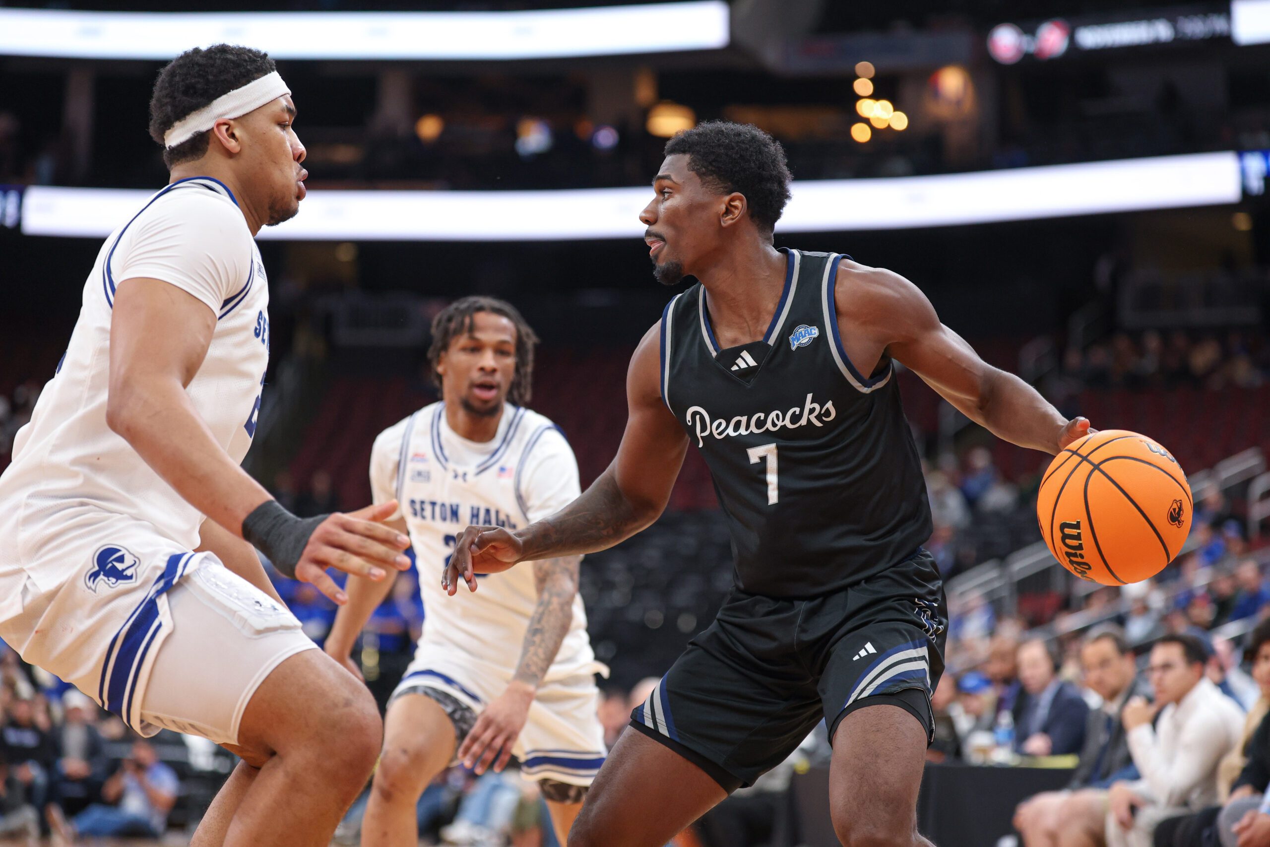 Nov 3, 2025; Newark, New Jersey, USA; Saint Peter's Peacocks guard Elijah Perkins (7) dribbles as Seton Hall Pirates center Najai Hines (25) defends during the first half at Prudential Center. Mandatory Credit: Vincent Carchietta-Imagn Images