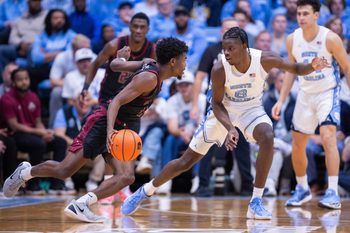 Nov 14, 2025; Chapel Hill, North Carolina, USA; North Carolina Tar Heels forward Caleb Wilson (8) guards North Carolina Central Eagles guard Gage Lattimore (11) during the second half at Dean E. Smith Center. Mandatory Credit: Scott Kinser-Imagn Images